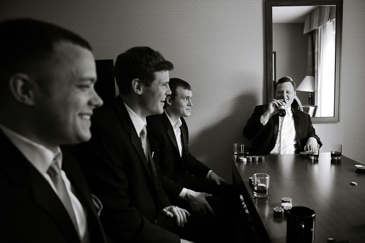 groom playing poker with groomsmen before branford house wedding