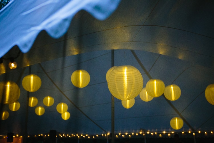 artistic photo of paper lanterns inside a wedding tent