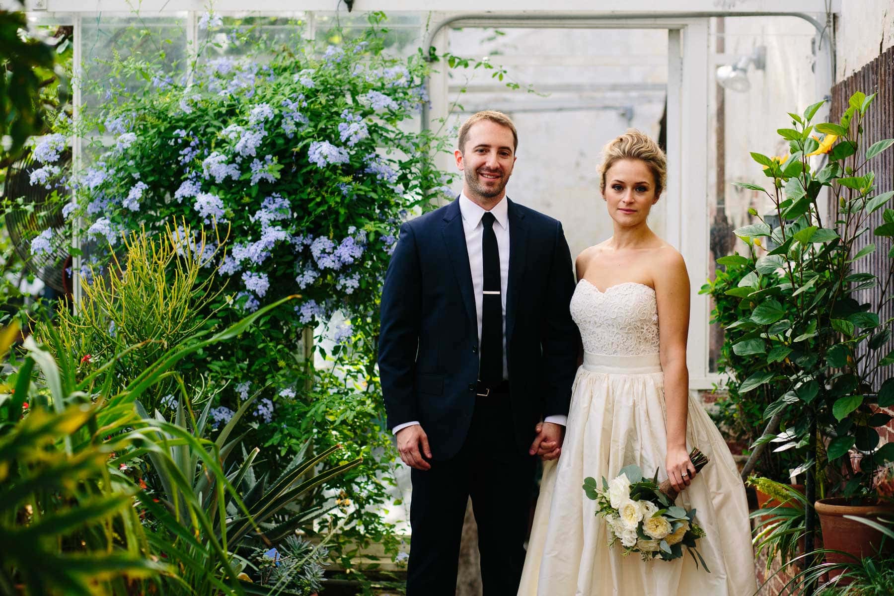 bride and groom pose inside greenhouse at Lyman Estate wedding