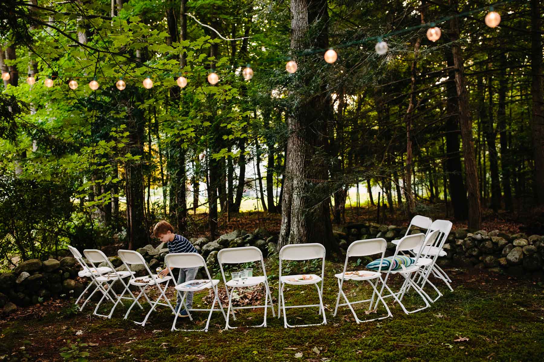 a child plays in the twilight during a backyard wedding reception | Kelly Benvenuto Photography