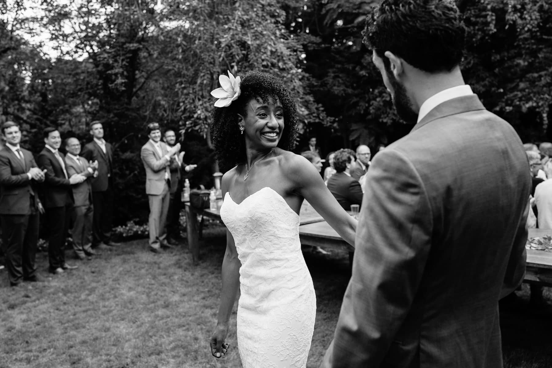 bride smiles at groom after recessional at a backyard wedding ceremony
