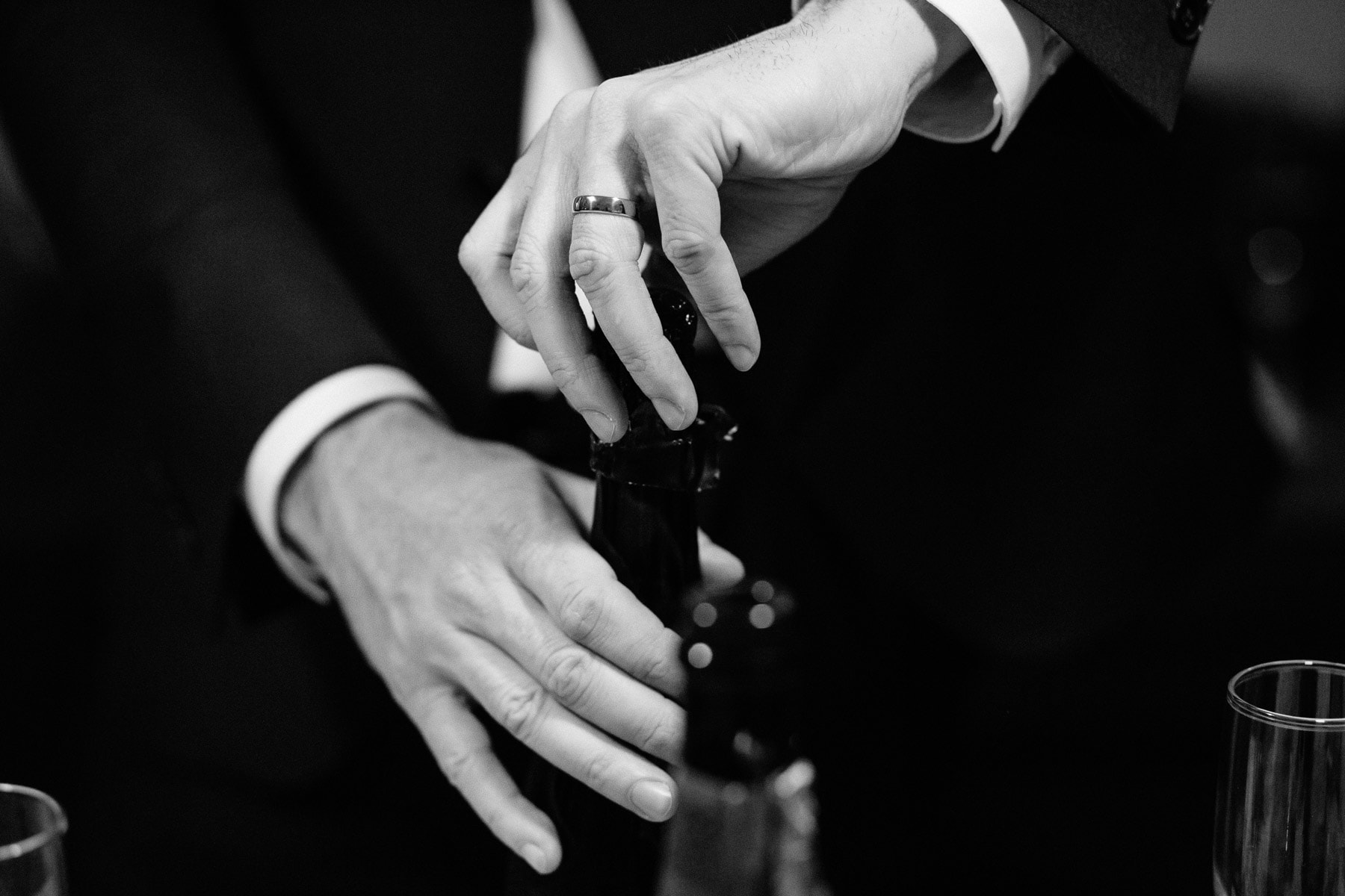 groom opening champagne with a new ring on his finger | boston wedding photographer