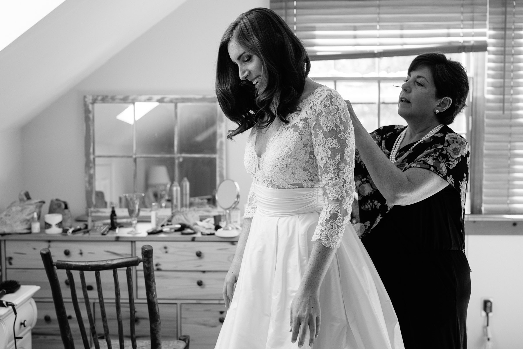mother buttons her daughter into wedding dress