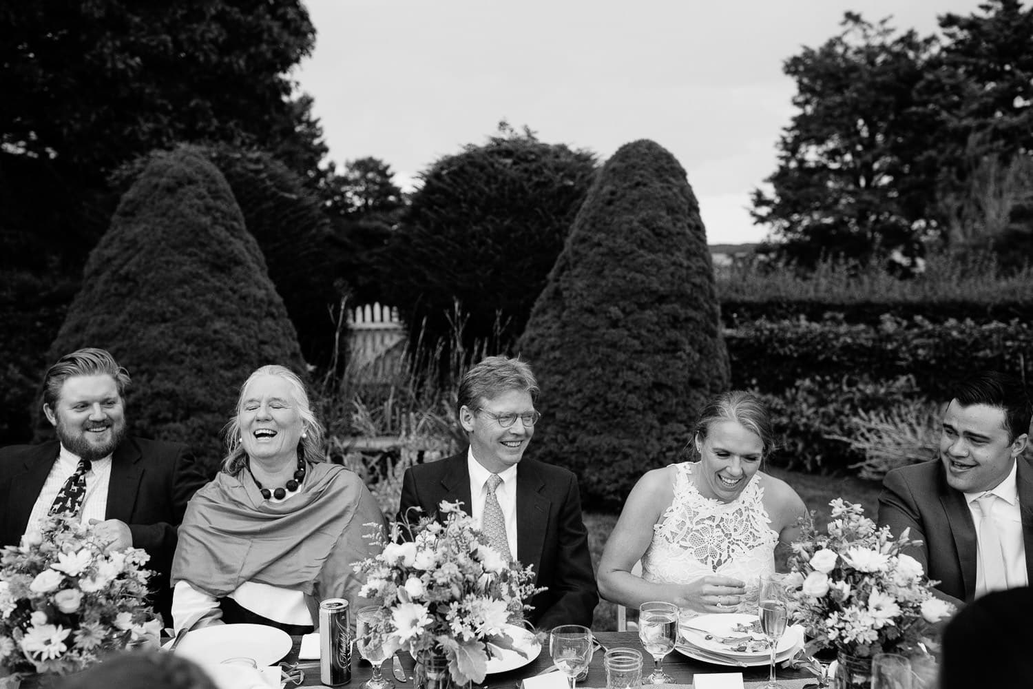guests laugh at alfresco wedding reception