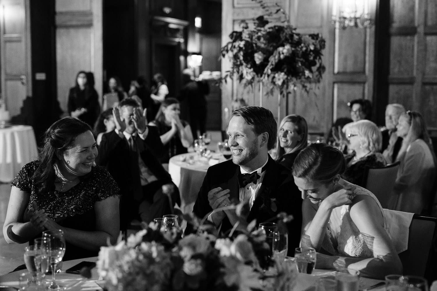 bride and groom react to a toast during their Harvard Club of Boston wedding reception