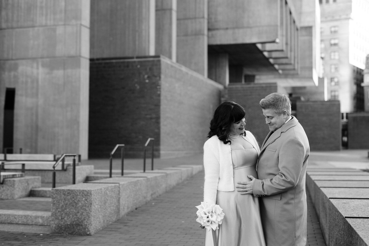 black and white image of couple in Boston city hall plaza