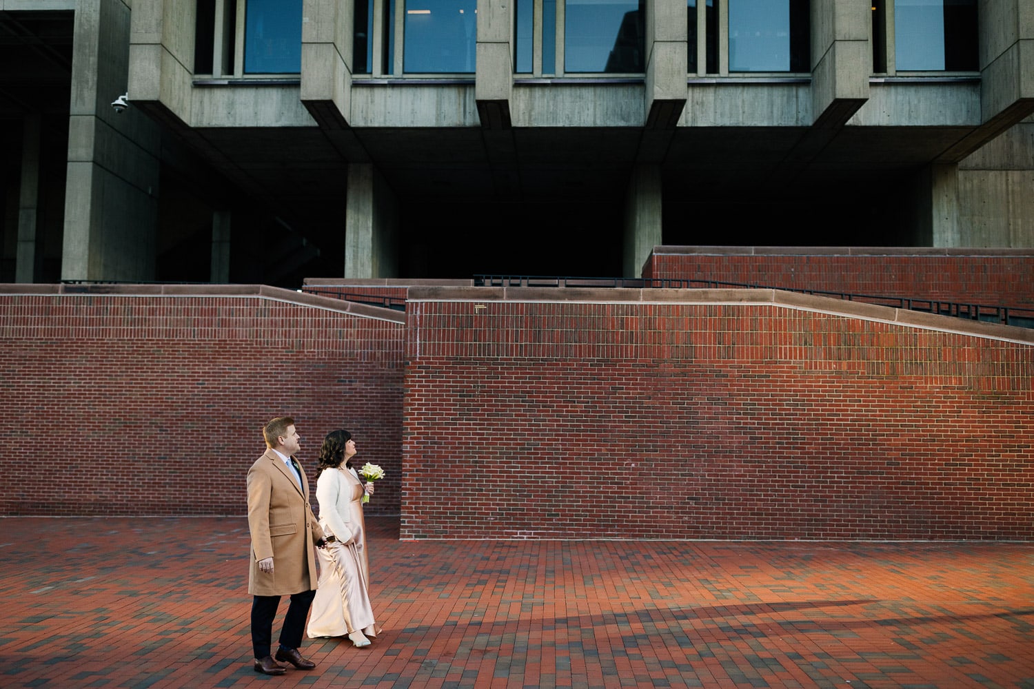couple walking in front of Boston city hall